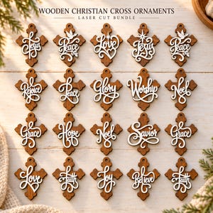 May include: A collection of twenty wooden Christian cross ornaments featuring laser-cut white script text including words like Jesus, Peace, Love, Glory, Worship, Noel, Grace, Hope, Savior, Faith, Joy, and Believe, each with a small hole for hanging.