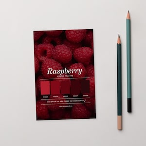 Könnte beinhalten: Eine Farbpalettenkarte mit einem Hintergrund aus frischen Himbeeren. Die Karte zeigt das Wort "Raspberry" und eine Reihe roter Farbfelder mit Hex-Codes. Zwei Bleistifte, einer türkis und einer grün, sind rechts positioniert.