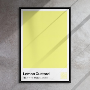 Puede incluir: Un póster enmarcado con un bloque de color crema de limón. El póster tiene un marco negro con un borde blanco. El texto "Lemon Custard" se muestra en la parte inferior, junto con los códigos de color HEX y RGB. También hay un código QR.