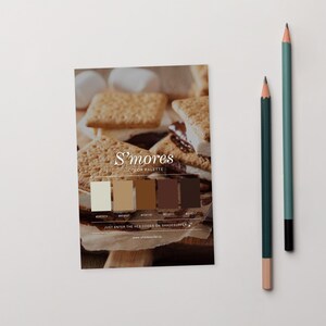 May include: A colour palette card labelled "S'mores COLOR PALETTE" with five colour swatches and hex codes. The card is next to two pencils, one green and one teal. The background shows a s'mores dessert.