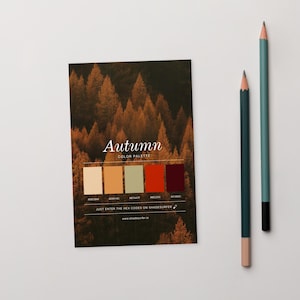 May include: A card featuring an autumn colour palette with a forest backdrop. The card displays five colour swatches and hex codes. Two pencils, one teal and one green, are positioned to the right of the card.