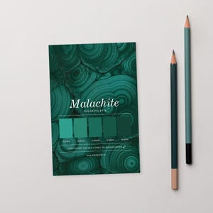 May include: A colour palette card featuring the word "Malachite" and a range of green colour swatches. Two pencils, one with a pink eraser, are positioned to the right of the card. The card also includes the text "Just enter the HEX codes on shadesurfer.io".