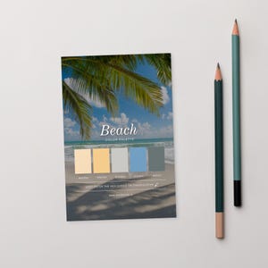 May include: A colour palette card with the word "Beach" and a beach scene, featuring shades of yellow, grey, blue, and green. Two pencils, one teal and one dark green, are positioned to the right.