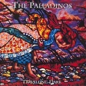 May include: A square album cover titled THE PALLADINOS and TRAVELLING DARK featuring a vibrant, expressionist painting of a figure in a patterned dress walking through a rocky landscape under a swirling, multi-colored sky of red, purple, and gold.