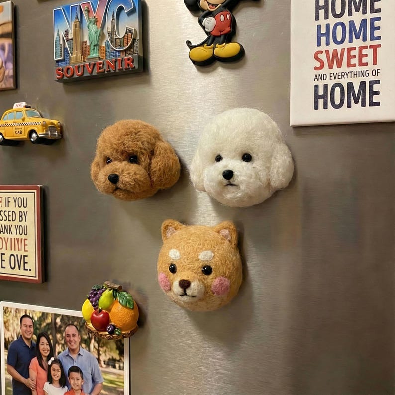 May include: A collection of decorative fridge magnets, including three dog-shaped magnets in brown, white, and tan. Other magnets include a yellow taxi cab, a New York City souvenir, and a sign that says "HOME SWEET HOME".