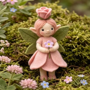 May include: A needle felted fairy figurine with pink hair, a pink rose headpiece, and a pink petal dress. The fairy has pointed ears, green felt wings, and holds a small purple flower. The figure is crafted with soft textures and pastel colors.