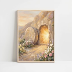 Puede incluir: Pintura enmarcada que representa una tumba abierta con una luz brillante que emana del interior. Una gran piedra descansa cerca. La escena está rodeada de flores en tonos rosa, blanco y morado, con una paleta de colores suave y cálida.