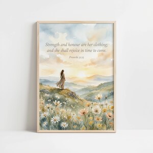 May include: Framed watercolour print featuring a woman on a hillside, with a mountain backdrop and sunset. The text reads: "Strength and honour are her clothing; and she shall rejoice in time to come. Proverbs 31:25."