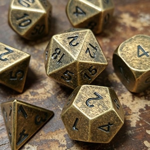 May include: A collection of antique brass-colored polyhedral dice, including D4, D6, D8, D10, D12, and D20. The dice have black numbering and a textured surface, resting on a wooden surface. Ideal for tabletop games.