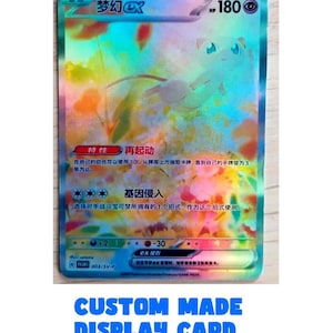 Op de afbeelding: Holografische ruilkaart met een cartoonfiguur, Japanse tekst en de tekst "HP 180". De kaart heeft een kleurrijke achtergrond en de tekst "梦幻EX". De onderkant van de kaart luidt "CUSTOM MADE DISPLAY CARD".