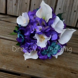May include: A purple and white bridal bouquet with calla lilies and hydrangeas. The bouquet is accented with teal blue flowers.