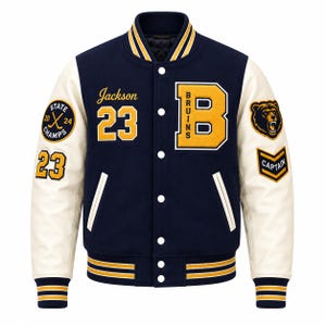 Può includere: Una giacca varsity blu navy e crema con una grande lettera B gialla con la scritta Bruins, il nome Jackson e il numero 23. Le maniche presentano toppe tra cui una testa di orso, un emblema State Champs 2024 e uno chevron da Captain.