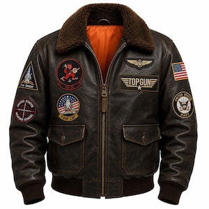 Puede incluir: Una chaqueta bomber de cuero marrón oscuro con cuello de piel sintética marrón y forro naranja brillante. La chaqueta presenta múltiples parches bordados, incluyendo un logotipo de Top Gun, una bandera estadounidense y varios emblemas de aviación.