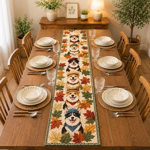Puede incluir: Una mesa de comedor de madera con un mantel decorativo con ilustraciones de perros corgi y hojas de otoño. La mesa está puesta con platos blancos, manteles individuales tejidos y cristalería. El ambiente es cálido y acogedor.