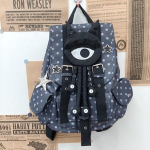 Dunkelgrauer Gothic-Rucksack mit Polka-Dots, Katzenohren-Horroraugen-Dekor, schwarzem Sternenaufnäher und Spiralsternkette im Y2K-Campus-Stil