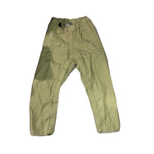 Puede incluir: Pantalones verde oliva con cintura elástica y corte holgado. Los pantalones tienen costuras verticales en la parte delantera de las piernas y una pequeña etiqueta cerca de la cintura. La tela parece ligera.