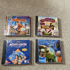 Puede incluir: Se muestran cuatro CD-ROM de Disney. Los títulos incluyen "The King and I Thinking Adventure", "Animated Storybook", "Aladdin Activity Center" y "Dinosaur Program Manual Activity Center". Las carcasas están en buen estado.