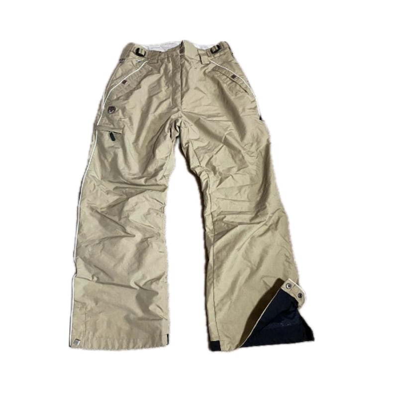 May include: Tan snow pants with white trim and multiple pockets. The pants have a relaxed fit and feature a black interior at the bottom of the legs. The pants are designed for winter sports and outdoor activities.