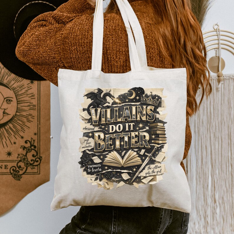 May include: Cream-colored tote bag with the text "Villains Do It Better" in a stylized design. The design includes a dragon, a crown, and an open book. Additional text includes "obsessed," "just five minutes," "enemies to lovers," and "the villain gets the girl."