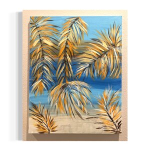 May include: An acrylic painting of a beach scene with palm fronds. The artwork features a light blue sky and a sandy beach. The palm fronds are painted in shades of yellow, orange, and brown, creating a tropical aesthetic. The painting is framed.
