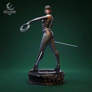 Könnte beinhalten: Schwarz-silberne Statue einer weiblichen Figur in futuristischer Kleidung, die einen leuchtenden Ring und ein Schwert hält. Die Statue steht auf einem Sockel mit dem Wort "TRON" und dem Logo "SCULATIVE". Die Figur ist dynamisch vor einem dunkelgrünen Hintergrund posiert.