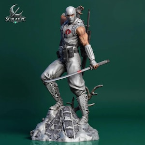 May include: A detailed statue of a character in a white and gray tactical suit, holding a katana. The figure is posed dynamically on a rocky base, with a logo in the upper left corner. The character has a mask and is ready for action.