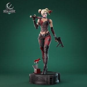 May include: A detailed figurine of a character with blonde pigtails, wearing a red and black corset, pants, and boots. The figure holds a baseball bat and a gun. A jack-in-the-box is at the character's feet. The base is dark gray.