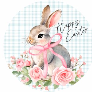 May include: A watercolour illustration of a grey bunny with a pink ribbon and flowers on a blue and white gingham background. The text "Happy Easter" is written in black cursive.