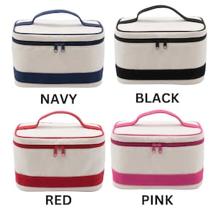 May include: Four cosmetic bags with white canvas fabric and colored trim. The bags have a zipper closure and a top handle. The colors are navy, black, red, and pink.