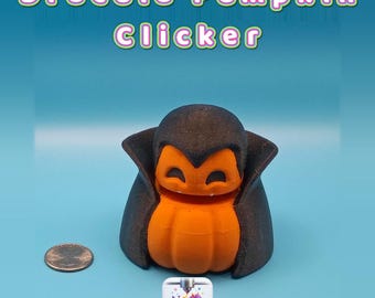 May include: A 3D-printed Dracula Pumpkin Clicker toy featuring a black cape and orange pumpkin body with two small white fangs. The text Dracula Pumpkin Clicker is displayed above, and a US quarter coin is placed to the left for scale.