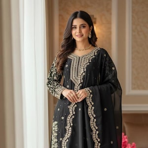 Può includere: Completo formale nero ricamato. L'outfit include una tunica a maniche lunghe, pantaloni a gamba larga e una sciarpa abbinata. L'intricato ricamo dorato adorna lo scollo, le maniche e l'orlo, creando un aspetto lussuoso. Adatto per occasioni speciali.