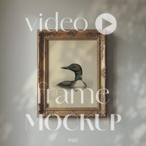 May include: A rectangular ornate gold-colored picture frame containing a vintage-style illustration of a loon swimming on water. The text "video frame MOCKUP PSD" is overlaid on the image, along with a circular play button icon.