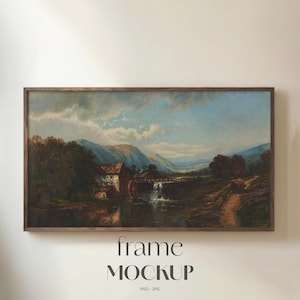 May include: A framed landscape painting depicting a watermill, river, and mountains. The artwork has a vintage aesthetic with a brown wooden frame. The sky is blue with clouds. The text "frame MOCKUP" is at the bottom.