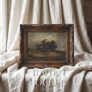 May include: A rectangular picture frame with an ornate, dark brown carved wood finish. The frame contains a landscape painting depicting a cluster of trees under a cloudy sky. The text "frame MOCKUP PSD - JPG" is overlaid in white lettering.