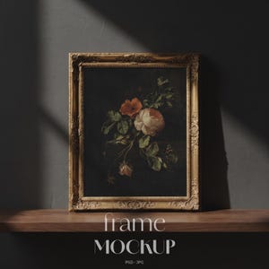 May include: A framed floral still life painting with a gold ornate frame. The artwork features red and white roses with green leaves against a dark background. The words "frame MOCKUP" are at the bottom of the image.