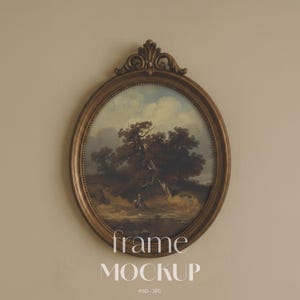 May include: An oval-shaped antique-style frame with an ornate decorative crest at the top, finished in a muted bronze tone. The frame contains a landscape painting depicting dark trees, a cloudy sky, and a small figure in a field. Text reads frame MOCKUP.