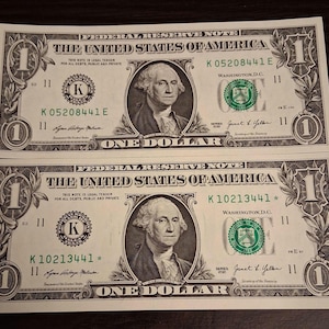 Two crisp uncircluated 1 dollar bills.  One * star note and one regular note. Both notes from 2021 series Dallas District (K11).