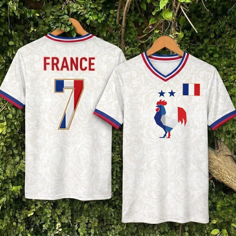 May include: White jersey with the word "FRANCE" in red, and the number 7 with the French flag colors. The front of the jersey features a rooster, two stars, and the French flag. The jersey has blue and red trim.