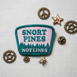 May include: A white ceramic mug with a black handle and the text "But First, Coffee" in a black, handwritten-style font. The mug is on a white surface.