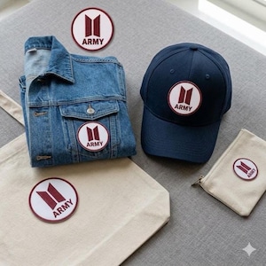 May include: A white ceramic mug with a black handle and the text "But First, Coffee" in a bold, black font. The mug is set against a blurred background, suggesting a cozy setting.