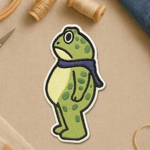 May include: A white ceramic mug with a black handle and the text "But First, Coffee" in a bold, black font. The mug is set against a blurred background, suggesting a cozy setting.