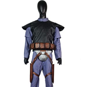 May include: A costume set featuring a light purple long-sleeved shirt and matching trousers, a black chest plate with shoulder guards, a brown leather utility belt with multiple pouches, and a silver-coloured codpiece with brown leather straps.