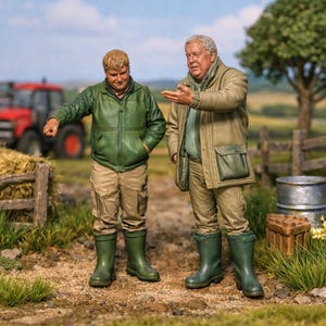 May include: Two miniature figurines of farmers in a rural setting. One figure points towards the left, while the other gestures with an open hand. Both wear jackets, pants, and boots. A red tractor and hay bales are visible in the background.