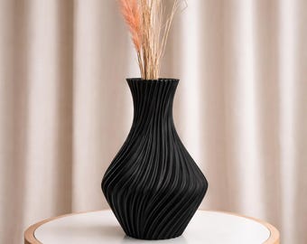 Jarrón decorativo negro con diseño ondulado.