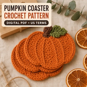 May include: Three orange pumpkin-shaped crochet coasters with brown stems and green leaves. The text PUMPKIN COASTER CROCHET PATTERN DIGITAL PDF US TERMS is displayed in a white box above the coasters, which are arranged on a light fabric.