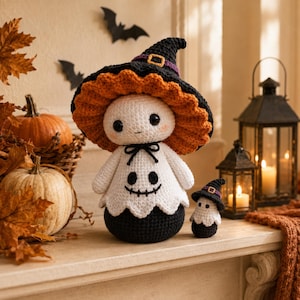 May include: A large and a small crochet doll, both featuring white ghost bodies with black stitched faces, wearing black witch hats with orange ruffled brims and purple bands with gold buckles. The dolls have black rounded bases.