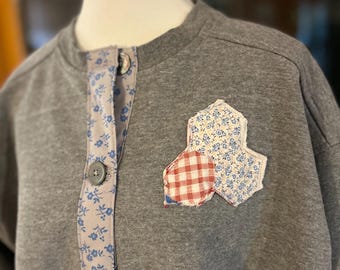 Sudadera estilo abuela con botones vintage y apliques acolchados en azul/gris.