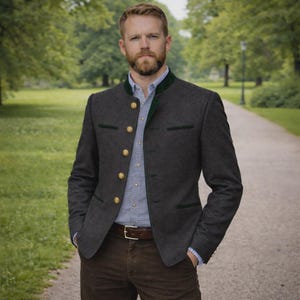 May include: A dark gray jacket with green trim and gold buttons. The jacket is worn over a light blue button-down shirt and brown pants. A brown leather belt is visible. The person is standing on a path in a park.