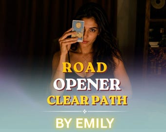 May include: A rectangular tarot card featuring a blue and gold illustration of a moon and landscape, held upright. The text ROAD OPENER CLEAR PATH BY EMILY is overlaid in bold yellow and white lettering against a dark, dimly lit background.