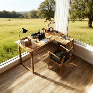 May include: A wooden L-shaped desk with a black desk lamp, a laptop, and a wicker basket. A black chair with a leather seat is next to the desk. The desk is in a room with a large window overlooking a green field.